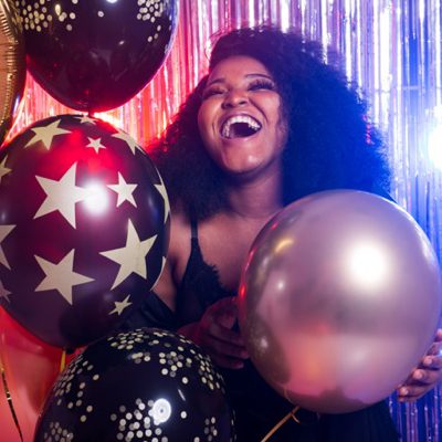 Portrait of a beautiful african american woman against twinkling background. Birthday party, nightclub and nightlife.